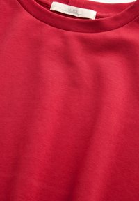 Red cotton T-shirt featuring a crew neckline, smooth texture, and a label with "N. 82" at the back. No distinct patterns or accents visible.