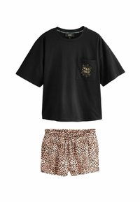 Črna oversized majica s kratkimi rokavi z napisom "Wild Child" na žepu, v kombinaciji z visokim pasom leopardjasto potiskanimi kratkimi hlačami z vrvico.