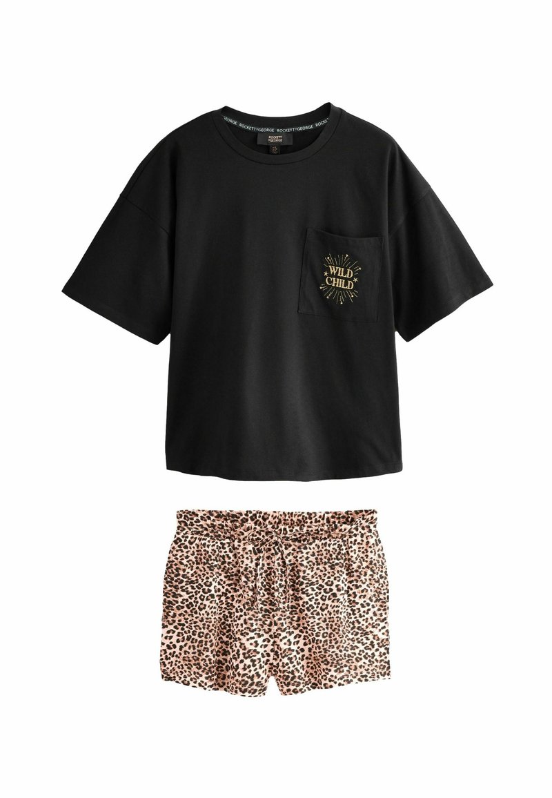 Črna oversized majica s kratkimi rokavi z napisom "Wild Child" na žepu, v kombinaciji z visokim pasom leopardjasto potiskanimi kratkimi hlačami z vrvico.