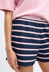 Marineblaue und rosa gestreifte Shorts aus weichem Stoff. Verfügen über einen elastischen Bund mit dem "TOMMY HILFIGER"-Logo. Freizeitdesign für Komfort.