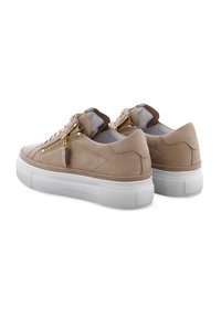 Beige Wildlederschuhe mit einer strukturierten weißen Gummisohle, ausgestattet mit goldenen Reißverschlüssen an beiden Seiten und einem niedrigen Profil.