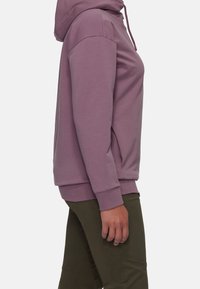 Huvtröja i mauve tyg, med avslappnad passform, kängurufickor och ribbade muddar, stylad med olivgröna byxor.