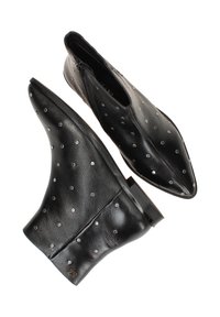 Botas de cuero negro hasta el tobillo con punta afilada, decoradas con detalles de puntos plateados y una textura suave. Incluyen una cremallera lateral para facilitar su uso.
