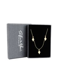 Collana d'oro con tre pendenti a forma di diamante su una delicata catena, presentata in una scatola regalo grigia con una texture e un interno nero.