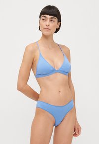 Light blue bikini featuring a triangular top with thin straps and a matching bottom. Smooth texture and minimalistic design with no patterns.
