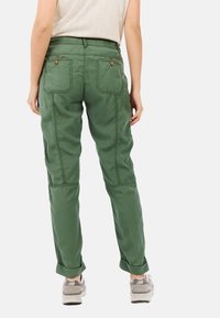 Groene cargo broek met een ontspannen pasvorm, voorzien van een gecuffte enkel, opgestikte zakken op de achterkant en contrasterende stiksels.