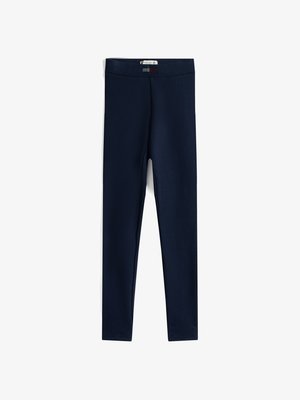 Tops od mornarsko modrih legginsa, izdelanih iz elastičnega blaga. Imajo širok, elastikast pas in gladko teksturo brez vidnih vzorcev ali poudarkov.