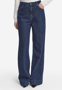Breda denimjeans i en mörk indigo tvätt, med hög midja, klassisk fem-fickors design och subtila sömmar.
