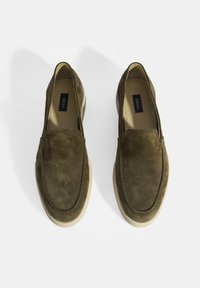 Olivgrüne Wildleder Slipper mit flacher Gummisohle, akzentuiert durch ein gestepptes Design entlang der Kante und einem bequemen Innenfutter.