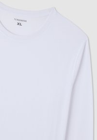 Biała koszulka z długim rękawem wykonana z miękkiego materiału, z okrągłym dekoltem. Widoczna metka z napisem "TERRANOVA" i rozmiarem "XL".