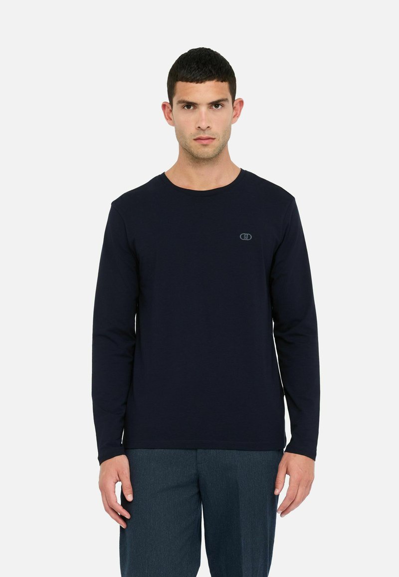 Maglietta a maniche lunghe di colore navy realizzata in morbido tessuto, caratterizzata da un colletto rotondo e un piccolo logo sul petto. Texture liscia e vestibilità regolare.