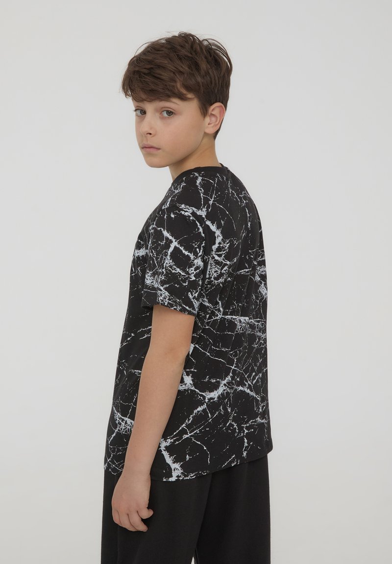 T-shirt nero a maniche corte con motivo in marmo bianco, realizzata in morbido cotone, con scollatura rotonda e vestibilità comoda.