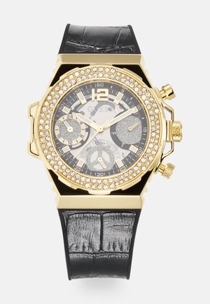 Goldfarbener Uhr mit einem schwarzen Krokodilgeprägten Lederband. Verfügt über eine Kristalllünette, ein Zifferblatt mit mehreren Ziffern und goldene Zeiger mit einer 12 als Marker.