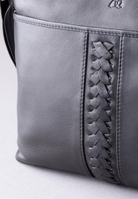 Black leather shoulder bag featuring a woven texture detail along the side, smooth finish, and subtle stitching accents.