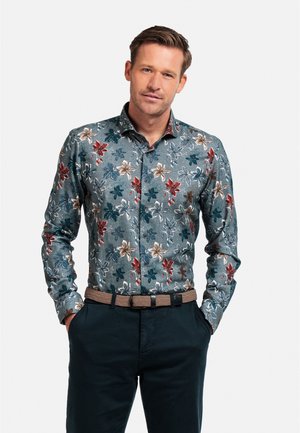Chemise à boutons à motif floral présentant des fleurs multicolores sur fond turquoise, manches longues et col structuré.