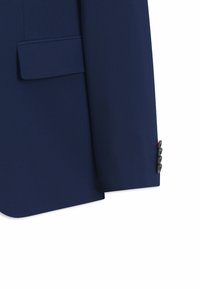 Mouw van een marineblauw kostuumjasje en voorkant met klepzak en vier zwarte knopen op de manchetten, weergegeven tegen een witte achtergrond.