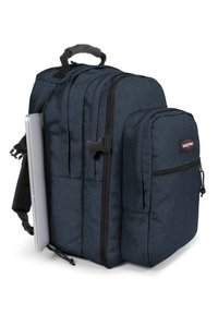 Zaino in tessuto blu scuro con più scomparti, una tasca laterale e una sezione imbottita per laptop. Presenta una maniglia superiore e spallacci regolabili.