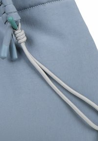 Tela de color azul claro con una textura suave, que cuenta con un cordón gris con puntas de plástico. Los detalles incluyen una sección anudada para ajustar.