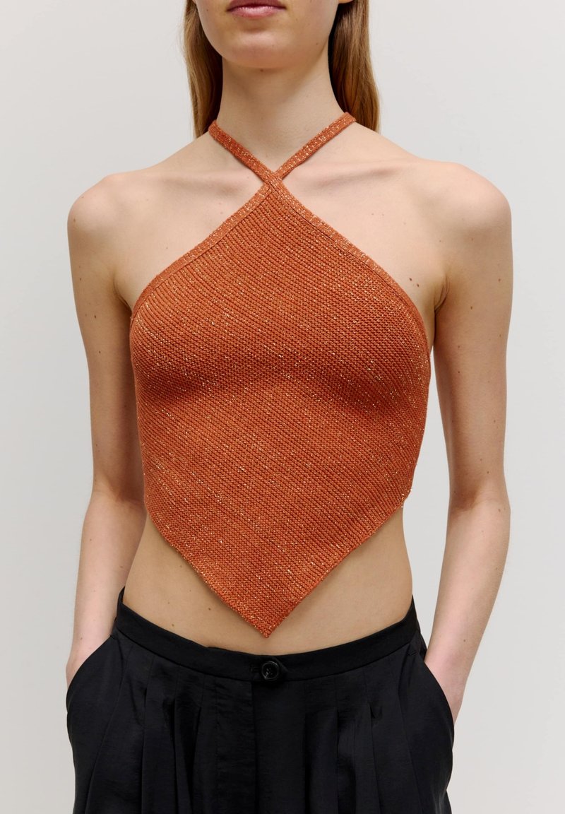 Orange Haltertop mit diagonellem Saum, ausgestattet mit einem strukturierten Strickdesign. Der Stoff hat einen leichten Glanz und wird durch eine minimalistische Silhouette ergänzt.