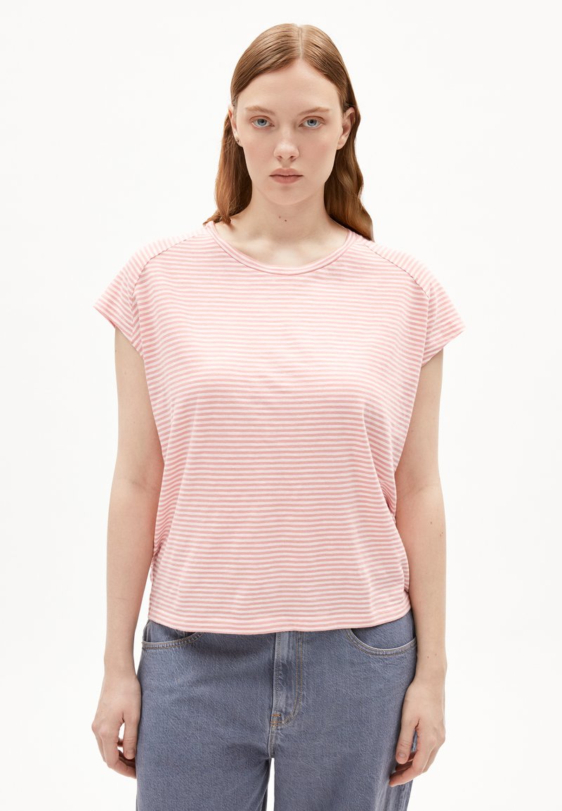 T-shirt à manches courtes rayé rose et blanc avec un col rond et une coupe décontractée, associé à un jean bleu taille haute. Texture de tissu douce.
