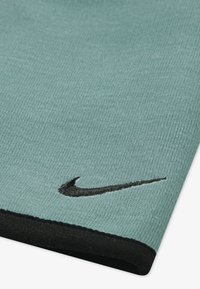Textile Nike en bleu clair avec une texture lisse, présentant un logo swoosh noir et un bord noir en bas.
