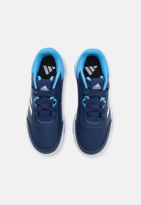 Baskets de sport bleues avec une tige en cuir texturé, un col rembourré et des accents blancs. Présentent des lacets bleus et une semelle intérieure noire avec un logo.