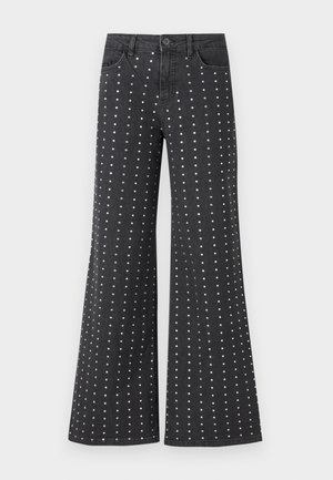 Sorte, utvidete denimjeans med et mønster av små sølvnagler ordnet vertikalt. Fem lommer og en knappelukking er inkludert.