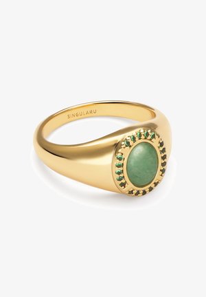 Bague en or ornée d'une pierre verte ovale au centre, entourée de petits gemmes vertes dans un sertissage circulaire. Fini lisse et poli.
