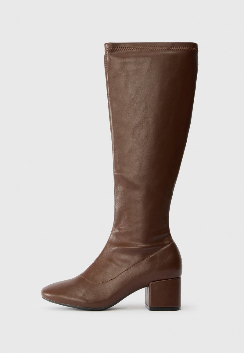 Brown leather knee-high boots with a pointed toe and block heel. Smooth texture, minimal stitching detail along the top edge.