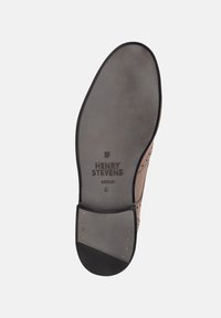 Semelle de chaussure en cuir brun avec une finition lisse, comportant un logo, un bout arrondi et de petites clous métalliques près du talon. Taille 8.