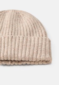 Gorro de tricô em bege claro com uma textura canelada, apresentando uma aba dobrada e detalhes discretos salpicados por todo o tecido.