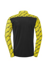 Langarmshirt met een zwarte body en levendige gele mouwen, die een gedurfde, getextureerde patroon tonen in zwarte lijnen en gekartelde accenten.