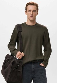 Donkergroen shirt met lange mouwen van gladde stof, gecombineerd met een zachte, donkergrijze suède tas, voorzien van stevige handvatten en een schouderriem.