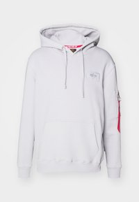 Felpa grigia chiara con tasca frontale, cordini e una piccola etichetta con logo. Presenta una tasca con zip sulla manica con un accento rosso.