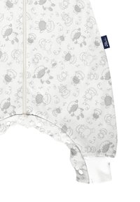 Weißer Jumpsuit mit grauen Schafsmustern, langen Ärmeln, Reißverschluss vorne und Druckknöpfen an den Knöcheln. Aus weichem Baumwollmaterial.