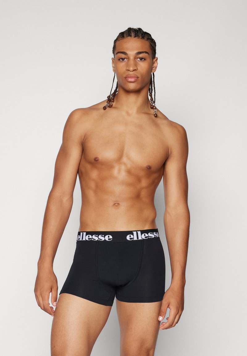 Black boxers made of cotton featuring a white "ellesse" logo on the waistband. They have a fitted design and smooth texture.