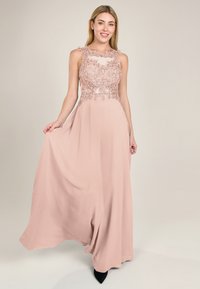 Abito rosa pallido con corpino in pizzo, ricami floreali, design senza maniche e gonna fluente. Presenta un collo a scollatura scallop e una silhouette elegante.