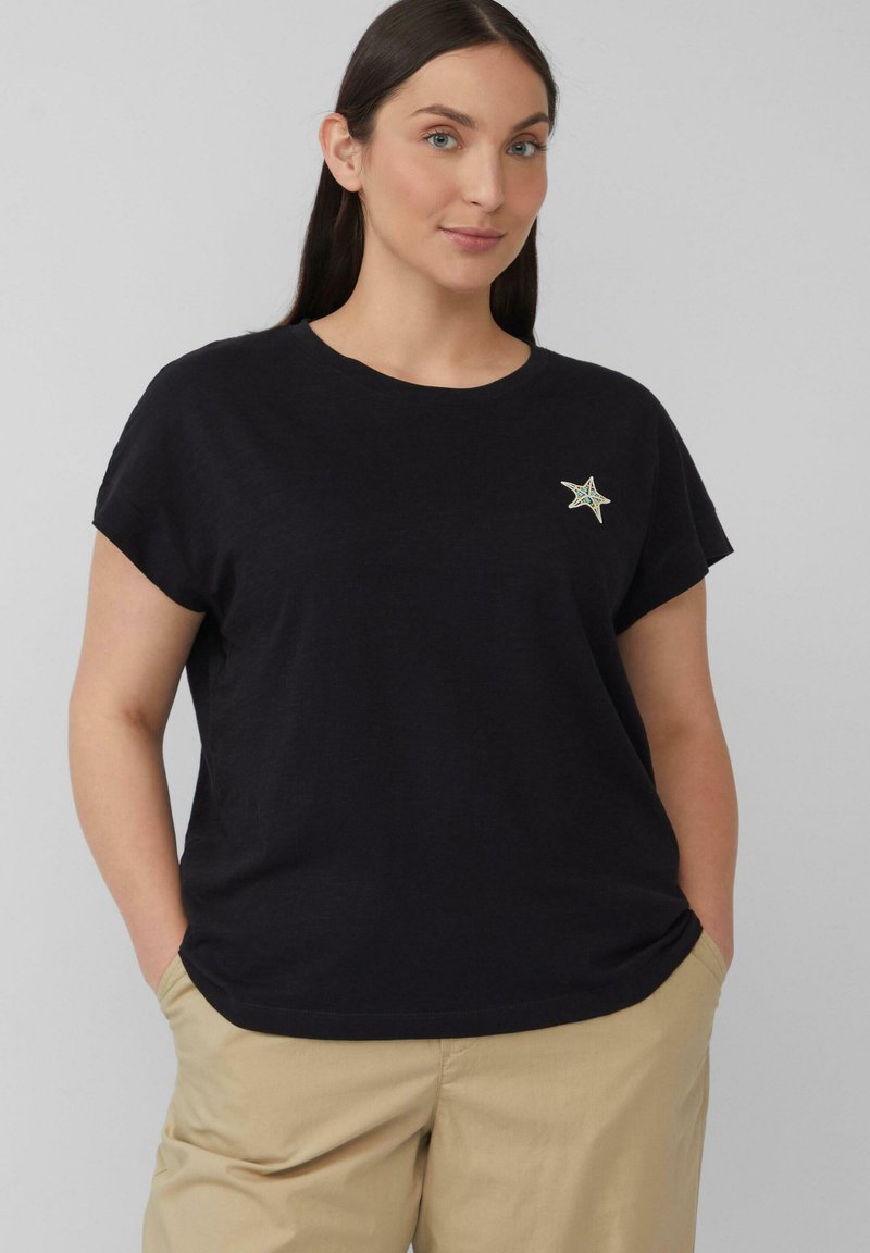 Zwarte T-shirt met korte mouwen van zachte katoen, met een klein geborduurd steraccent op de linkerkant van de borst. Casual pasvorm.