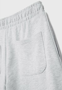 Grijze sweatpants gemaakt van een zachte, lichte stof. Voorzien van een elastische tailleband en achterzakken met simpele stiksels.