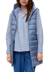 Gepolsterte Weste in Hellblau mit Kapuze, ausgestattet mit gesteppten Abschnitten, einem Reißverschluss vorne und tiefen Seitentaschen, darüber ein gestreiftes Hemd.