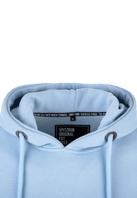 Hellblaue Kapuzenjacke mit Kordelzug, ausgestattet mit einem strukturierten Stoff und einem Etikett innen mit Marken- und Größenangaben.