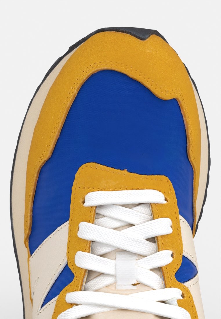 Blauwe en gele sneaker met een gladde textielen bovenkant, witte veters en een zwarte rubberen zool. Heeft een gelaagd ontwerp en contrasterende kleuren.