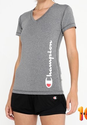Graues kurzärmliges V-Ausschnitt-T-Shirt mit einem weißen "Champion"-Logo auf der linken Seite; getragen mit schwarzen Mesh-Shorts, die ein Logopatch haben.