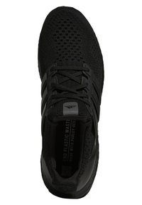 Chaussure de sport noire avec une tige en maille texturée, des renforts superposés et une fermeture à lacets. Comprend un col rembourré et une semelle intérieure de marque.