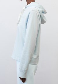 Felpa con cappuccio di colore azzurro chiaro realizzata in tessuto morbido, presenta una vestibilità comoda, polsini a costine e un cordino per il cappuccio.