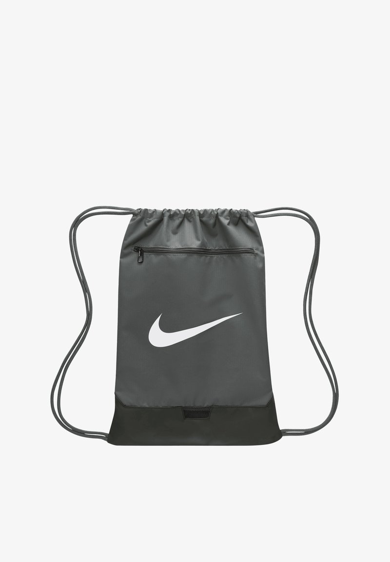 Drawstring backpack in dark gray, made of fabric. Features a white Nike logo, a small zipper pocket, and contrasting black bottom panel.