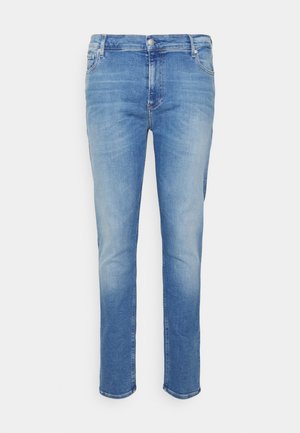 Heren slim-fit blauwe denim jeans met lichte vervaging op de dijen en een klassiek ontwerp met vijf zakken op een witte achtergrond.