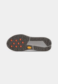 Semelle d'une chaussure avec une base en caoutchouc gris présentant un motif de semelle en forme de cœurs et des accents circulaires orange. Logo Vibram visible au centre.