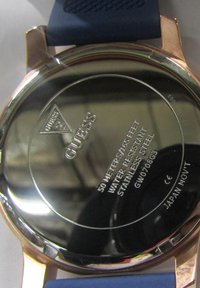 Fondo de reloj de acero inoxidable con superficie reflectante, logo grabado, información de resistencia al agua y correa de goma azul.