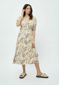 Midi-Wickelkleid aus einem fließenden Stoff, mit einem mehrfarbigen Muster in Blau-, Braun- und Cremetönen. Kurze Ärmel und ein Bindegürtel.